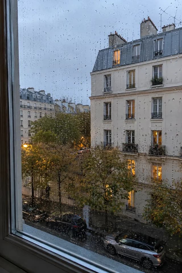 La pluie sur la fenêtre de l’appartement, face aux immeubles voisins.